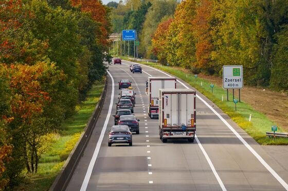 Autoroute belge bordée d'arbres aux couleurs d'automne avec circulation fluide